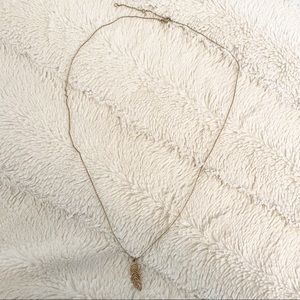 Gold tone necklace with feather pendant